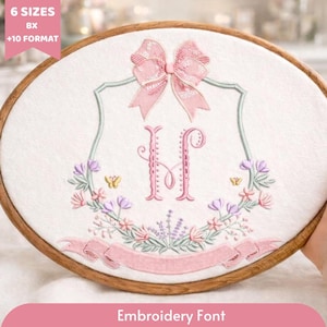 May include: An embroidered design featuring a pink bow, the letter "H", and floral elements, set within a wooden embroidery hoop. The design includes the text "Embroidery Font" at the bottom and "6 SIZES BX +10 FORMAT" at the top.