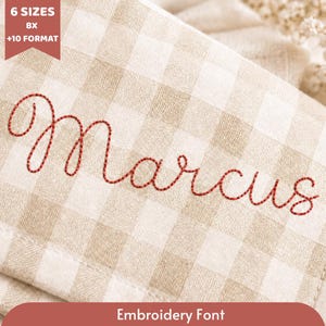 Pode incluir: Close-up de um tecido xadrez bege e branco com o nome "Marcus" bordado em escrita cursiva vermelha. O texto "6 Sizes BX +10 Format" está no canto superior esquerdo. O texto "Embroidery Font" está na parte inferior.