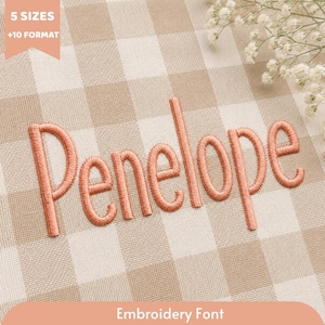 May include: The name Penelope is embroidered in a coral-colored thread on a beige and white gingham fabric. A peach-colored banner in the top left corner displays the text 5 SIZES +10 FORMAT, and a bottom banner reads Embroidery Font.