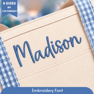 May include: A beige canvas fabric featuring the name Madison embroidered in blue script lettering. The fabric is accented with blue and white gingham check trim along the edges. Text in the corner reads 6 SIZES BX +10 FORMAT.