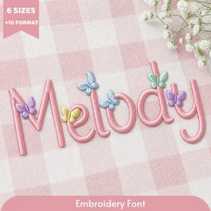 Op de afbeelding: De naam Melody is geborduurd in roze garen op een wit en roze geruite stof. Kleine, kleurrijke vlinders in tinten paars, geel, blauw en groen zijn op de letters geplaatst. De tekst in de hoek luidt 6 SIZES +10 FORMAT.