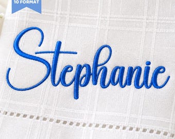 Peut inclure: Gros plan sur un tissu blanc avec le nom "Stephanie" brodé en bleu en écriture cursive. Le tissu présente un motif quadrillé subtil et une bordure décorative. Le texte en haut indique "6 SIZES BX + 10 FORMAT". Le texte en bas indique "Embroidery Font".