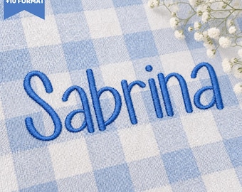 Peut inclure: Le prénom Sabrina est brodé en fil bleu sur un tissu à carreaux vichy bleu clair et blanc. Un petit bouquet de fleurs blanches gypsophile est visible dans le coin supérieur droit. Une étiquette bleue en haut à gauche indique 5 SIZES +10 FORMAT.