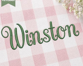 Peut inclure: Un motif de broderie affichant le prénom Winston dans une police cursive verte, cousu sur un tissu à carreaux vichy rose clair et blanc. L'image comprend une étiquette verte indiquant 6 SIZES +10 FORMAT et un petit bouquet de fleurs blanches.