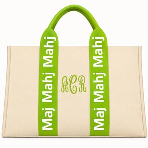 May include: A beige tote bag featuring two lime green vertical straps with the white text "Maj Mahj Mahj" printed on each. The center of the bag displays a lime green embroidered monogram with the letters "ACR" in a cursive script font.