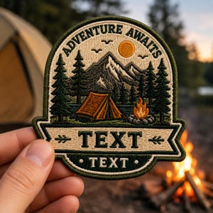 May include: An embroidered patch featuring a mountain landscape with a tent, a campfire, and pine trees. The text ADVENTURE AWAITS is arched at the top. Below the scene, a banner contains the word TEXT with arrows, and a lower section displays TEXT.