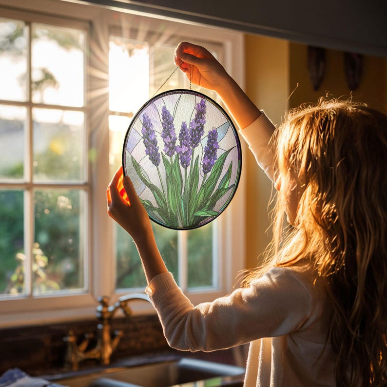 May include: A round stained glass window hanging with a purple and green lavender design.