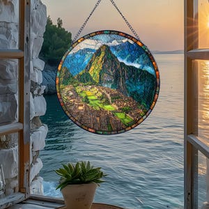 May include: A round stained glass window depicting Machu Picchu, with a chain for hanging. The artwork features a vibrant landscape of green mountains, ancient ruins, and a blue sky. The window is framed with colorful glass.