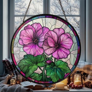 May include: A stained glass window panel featuring two pink flowers with green leaves. The panel is round and has a black metal frame.