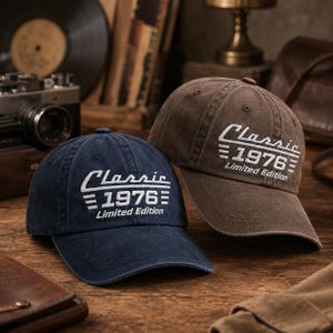May include: Two baseball caps, one in navy blue and one in brown, both featuring white embroidered text that reads Classic 1976 Limited Edition with horizontal lines on the front panels. Each cap has a curved brim and a structured crown design.