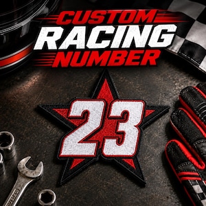 May include: A star-shaped embroidered patch featuring the number 23 in white with a black outline, set against a red background. The text CUSTOM RACING NUMBER is displayed in bold white and red lettering above the patch on a dark background.
