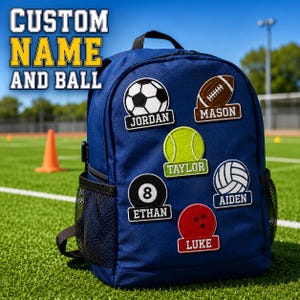 May include: A navy blue backpack featuring six embroidered patches of various sports balls, each with a name tag: Jordan with a soccer ball, Mason with a football, Taylor with a tennis ball, Ethan with an 8-ball, Aiden with a volleyball, and Luke with a bowling ball.