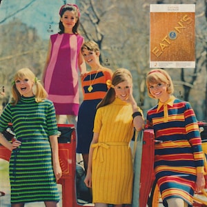 May include: Five women wearing different striped dresses. The dresses are in various colors, including green, pink, yellow, orange, and blue. The women are standing in front of a red carriage and a sign that says "EATONS".