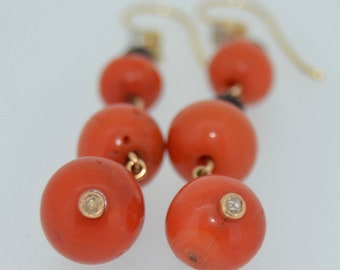 May include: A pair of coral and diamond drop earrings. The earrings feature a series of coral beads, with a diamond set in the bottom bead of each earring.