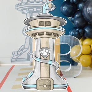 May include: A cartoon-style cutout of a tower with a light blue and beige color scheme, featuring a paw print emblem. The tower is part of a birthday party decoration, with a large number "3" and balloons in the background.