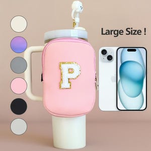 Könnte beinhalten: Eine rosa isolierte Wasserflasche mit weißem Griff und einem dekorativen wolkenförmigen Aufsatz. Die Flasche hat eine rosa Tasche mit einem goldverzierten weißen Buchstaben "P". Ein weißes Smartphone befindet sich neben der Flasche. Der Text "Large Size !" ist sichtbar.