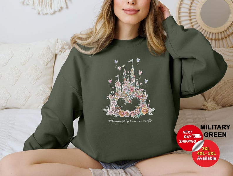 Puede incluir: Una sudadera verde con un dise&ntilde;o de castillo floral y el texto "Happiest place on earth".