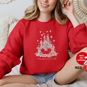 Puede incluir: Sudadera roja con un gr&aacute;fico blanco de un castillo con flores y el texto "Happiest place on earth".