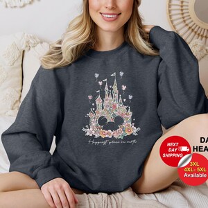 Puede incluir: Sudadera gris oscuro jaspeada con un dise&ntilde;o de castillo floral y el texto "Happiest place on earth".