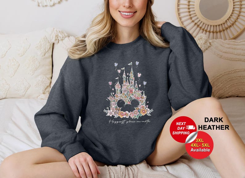 Puede incluir: Sudadera gris oscuro jaspeada con un dise&ntilde;o de castillo floral y el texto "Happiest place on earth".
