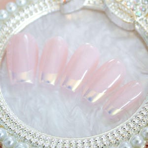 May include: Set of six oval-shaped false nails with a light pink base and a silver glitter accent at the tip.