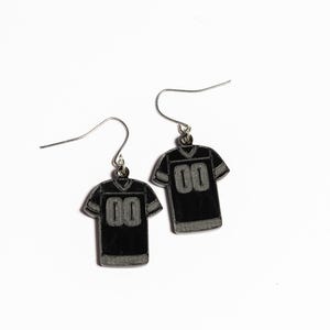 May include: A pair of black and silver earrings shaped like football jerseys with the number "00" on the front.