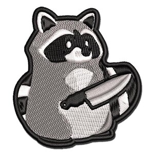 May include: Embroidered iron-on patch of a gray raccoon holding a knife. The raccoon has a black mask and white markings.