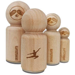 May include: A collection of wooden stamps featuring a sloth face design and a silhouette of a person in a dance pose. The stamps are in various sizes, with the text "SNIGGLESLOTH" on the sides.
