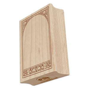 May include: A rectangular wooden stamp with a decorative brown border and arched top design. The stamp has a curved handle and a logo on the bottom. The stamp is made of light-colored wood.