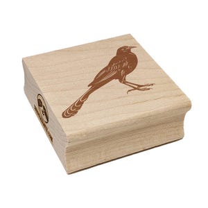 May include: A wooden stamp featuring a detailed illustration of a bird with a long tail and a curved beak. The bird is depicted in brown ink on a light-colored wooden block. The stamp has rounded edges and the text "www.etsy.com" is visible.
