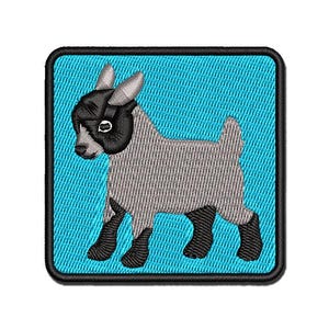 May include: A square embroidered patch featuring a light gray goat with a black face, black ears, and black legs. The goat is depicted in profile against a bright cyan background, with the entire design enclosed by a thick black border.