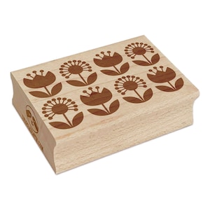 May include: A wooden rubber stamp with a repeating pattern of brown stylized flowers. The flowers have a simple design with rounded petals and leaves.