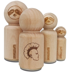 May include: Three wooden rubber stamps with different designs. The largest stamp features a black and white illustration of a person with a mohawk hairstyle. The text "SNUGGLESLOTHS" is printed on the side of the stamp. The medium-sized stamp features a cartoon sloth face. The smallest stamp features a cartoon sloth face.