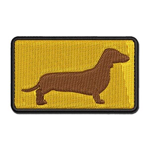 May include: A brown dachshund silhouette embroidered on a yellow fabric patch.