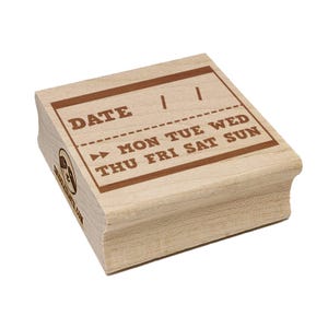 May include: A wooden date stamp with brown ink text. The stamp includes the word "DATE" at the top, with spaces for numbers, and the days of the week: MON TUE WED THU FRI SAT SUN. The stamp has a rounded edge.
