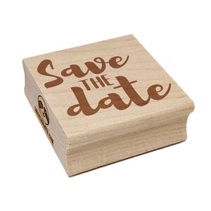 May include: A wooden stamp with the words "Save the Date" in a brown, cursive font. The stamp has a rectangular shape and a light wood color. The text is centered on the stamp.