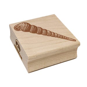 Könnte beinhalten: Ein Holzstempel mit einer braunen Illustration einer Muschel. Der Stempel hat eine rechteckige Form mit abgerundeten Kanten. Der Text "CHARLESCRAFTS.COM" ist auf der Seite des Stempels zu sehen.