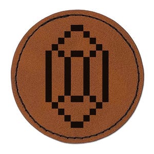 May include: A round, brown leather patch with a stitched border. The patch features a black, pixelated geometric design in the center, resembling a stylized arrow or building. The background is plain white.