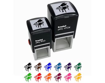 May include: Two black self-inking stamps with a piano design. The stamps are labeled "trodat printy 4923" and "trodat printy 4924". Below the stamps are examples of the piano design in various colors, including black, brown, blue, and green.