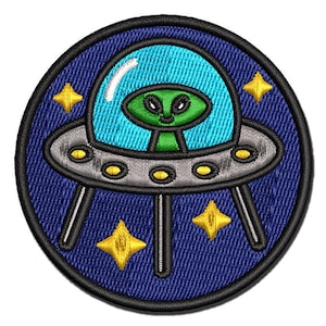 May include: A blue and white embroidered patch of a cartoon alien spaceship with a green alien inside. The spaceship has a gray rim and is surrounded by yellow stars.