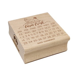 May include: A wooden stamp with the words "farm fresh" and a hen illustration. The stamp includes a calendar with months and dates, and the text "DATE GATHERED". The stamp is light brown.