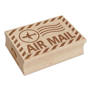 May include: A rectangular wooden stamp with the words "AIR MAIL" in bold letters. The stamp features an airplane inside a circle, with curved lines above the text. Brown diagonal lines and dots border the top of the stamp.