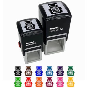 May include: Two black Trodat Printy 4923 and 4924 self-inking stamps with a white graphic of a warrior's face. The stamps are shown with a variety of colored ink options. The stamps are designed for office or craft use.
