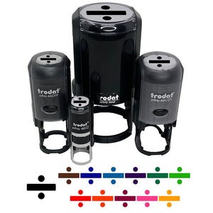 May include: A collection of black self-inking stamps with a division symbol on top. The stamps vary in size and have the brand name "trodat" printed on them. Below the stamps are color swatches of the division symbol in various colors.