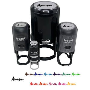May include: A collection of black self-inking stamps of various sizes, each labeled "Amen" in white. The stamps are from the brand "Trodat". Below the stamps, the word "Amen" is written in multiple colors.