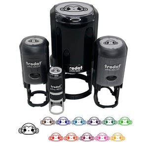 May include: A collection of black self-inking stamps with a monkey face design. The stamps are various sizes, with the brand name "trodat" visible. Below the stamps are several monkey face designs in different colors.