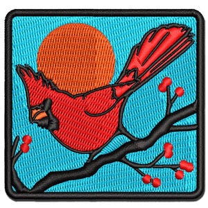 May include: A square embroidered patch featuring a bright red cardinal bird perched on a black branch with small red berries against a light blue background and a large orange sun, all enclosed within a thick black stitched border.