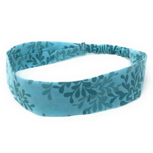 May include: A light blue headband with a floral pattern. The headband is made of fabric and has a stretchy elastic band.
