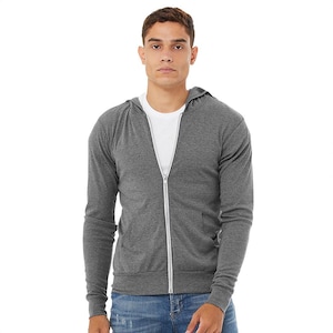 May include: A gray zip-up hoodie with a white zipper and a white t-shirt underneath. The hoodie has a hood and long sleeves. The person is wearing blue jeans.