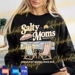 May include: Black sweatshirt featuring a beach scene graphic. The design includes the text "Salty Moms Beach Club" with illustrations of beach chairs, an umbrella, and ocean waves. The phrase "Girls Just Wanna Have Sun" is also included.